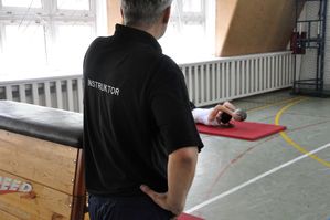 na zdjęciu instruktor oraz jeden z uczestników pokonujący tor przeszkód
