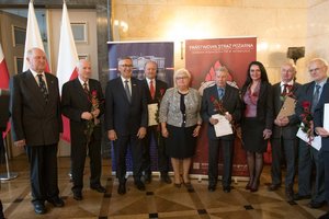 Zdjęcie kolorowe. Zdjęcie przedstawia wyróżnionych za działalność społeczną uczestników konferencji, oraz od lewej wicewojewoda śląski Jan Chrząszcz, Stanisław Szwed - Sekretarz Stanu w Ministerstwie Rodziny, Pracy i Polityki Społecznej,  poseł na Sejm RP Maria Nowak.