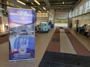 Na zdjęciu wnętrze stacji diagnostycznej i baner Wydziału Ruchu Drogowego KWP Katowice.