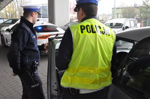 zdjęcie kolorowe: policjanci z grupy speed podczas wykonywania czynności na drodze. Kontrola samochodu pod wiaduktem.