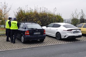 zdjęcie kolorowe: policjanci z grupy speed podczas wykonywania czynności na  drodze, stoją obok kontrolowanego pojazdu.