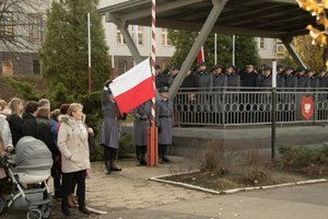 Zdjęcie kolorowe, przedstawiające policjantów niosących flagę.