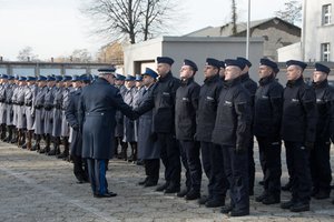 Zdjęcie kolorowe, przedstawiające Pana Komendanta składającego gratulacje nowo przyjętym policjantom.