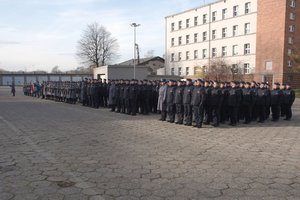 Zdjęcie kolorowe, przedstawiające nowo przyjętych policjantów podczas ślubowania, poczet sztandarowy, kompanię honorową KWP oraz orkiestrę policyjną.