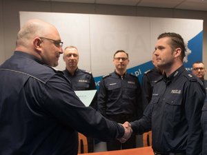 Zdjęcie kolorowe. Komendant Wojewódzki Policji w Katowicach nadinsp. dr Krzysztof Justyński wraz ze swoim Zastępcą gratuluje wyróżnionym policjantom