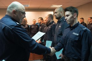 Zdjęcie kolorowe. Komendant Wojewódzki Policji w Katowicach nadinsp. dr Krzysztof Justyński wraz ze swoim Zastępcą gratuluje wyróżnionym policjantom