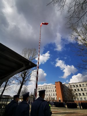 Policjanci podczas uroczystego podniesienia Flagi Państwowej. Widok na plac apelowy.