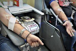 Osoby oddające krew , zbliżenie na ręce i aparaturę.