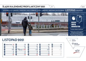 Jedenasta karta kalendarza z miesiącem listopad. Fotografia przedstawia przechodzącego przez przejście dla pieszych mężczyznę z dzieckiem mimo czerwonego światła. Z prawej strony karty widnieje napis: "Ucz dzieci dobrych zachowań. Edukuj dzieci dzięki specjalnie przygotowanym ośrodkom jak np. Centrum Bezpieczeństwa Ruchu Drogowego w Tychach".