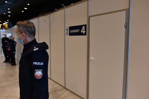 Policjant przed gabinetem szczepień