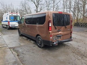 Rozbity radiowóz, a w tle karetka.