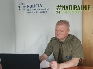 Jeden z prelegentów szkolenia. Ubrany w zielony mundur mężczyzna siedzi przed laptopem.