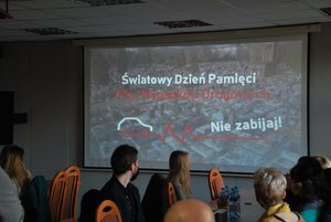 sala odpraw katowickiej komendy wojewódzkiej. Na sali znajdują się przedstawiciele mediów i młodzież, którzy oglądają przygotowany przez policjantów spot.