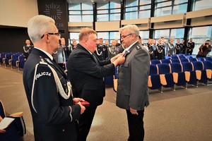 Zdjęcie przedstawia policjanta w trakcie odznaczenia go medalem przez Komendanta