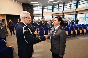 Zdjęcie przedstawia policjanta w trakcie odznaczenia go medalem przez Komendanta