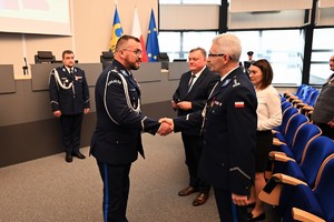 Zdjęcie przedstawia policjanta w trakcie odznaczenia go medalem przez Komendanta