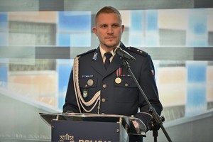 zdjęcie przedstawia policjanta prowadzącego uroczystość