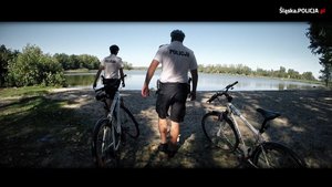 Zdjęcie. Widoczni dwaj policjanci z rowerami służbowymi