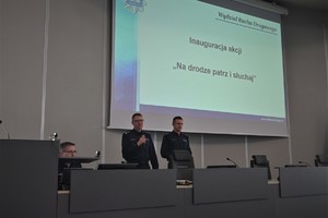 Zdjęcie. Widoczni umundurowani policjanci na scenie na auli