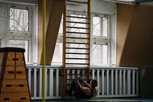 zdjęcie przedstawia osobę pokonującą tor przeszkód wykonującą skłony brzucha