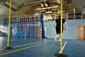 zdjęcie przedstawia osobę pokonującą tor przeszkód- bieg po wahadle