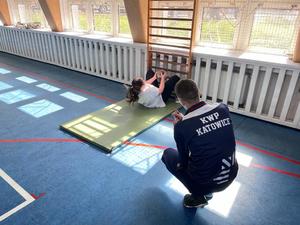 Na zdjęciu instruktor policyjny podczas nadzorowania wykonywania brzuszków przez uczestniczkę próbnego testu sprawnościowego.