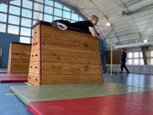 Na zdjęciu uczestniczka dnia  otwartego podczas pokonywania jednego z elementów toru przeszkód - skrzyni.