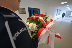 Zdjęcie. Widoczne kwiaty składane przed tablicą