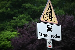 na zdjęciu znak strefa ruchu oraz uwaga rowerzyści z oznaczeniem szlaku rowerowego