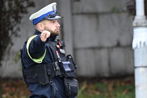 na zdjęciu policjant ruchu drogowego zatrzymuje pojazd