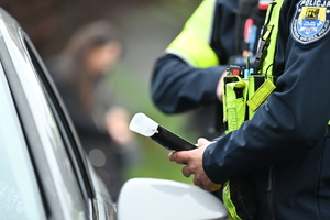 policjant ruchu drogowego podczas badania trzeźwości kierującego