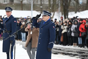 Komendant stoi za mikrofonem.