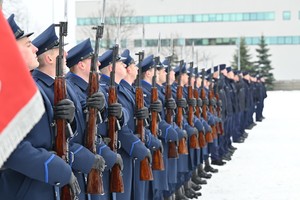 Policjanci z bronią stoją w szeregu.
