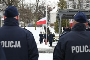 Flaga Polski unoszona ku górze.
