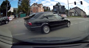 Stopklata z kamery samochodowej. Na zdjęciu czarny samochód bmw na skrzyżowaniu.