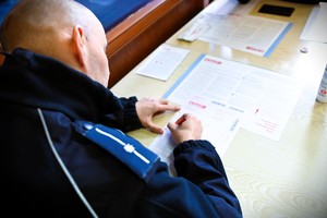 Policjant wypełnia formularze.