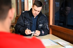 Policjant wypełnia formularz.