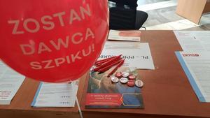 Zdjęcie. Osoba przy stanowisku DKMS z policjantem