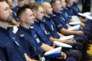 Na zdjęciu umundurowani policjanci siedzący na krzesłach.