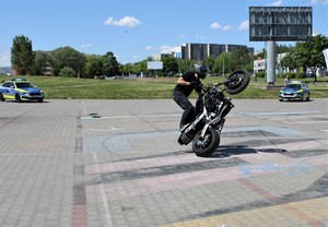 Na zdjęciu radiowozy policyjne oraz mężczyzna na motocyklu.