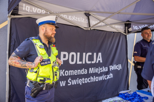 Umundurowany policjant na stoisku edukacyjnym