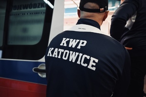 na zdjęciu widoczny jest mężczyzna ubrany w grantowa kurtkę z napisem KWP Katowice