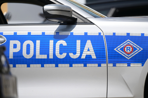 na zdjęciu fragment policyjnego radiowozu z napisem policja i logiem ruchu drogowego