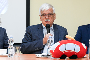 Na zdjęciu widoczny jest mężczyzna, który trzyma mikrofon w ręku.