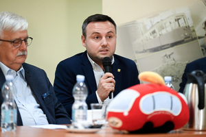 Na zdjęciu widoczny jest mężczyzna, który trzyma mikrofon w ręku.