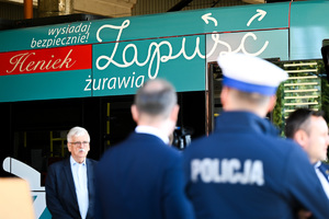 Na zdjęciu widocznych jest czterech mężczyzn a w tle znajduje się niebieski tramwaj.
