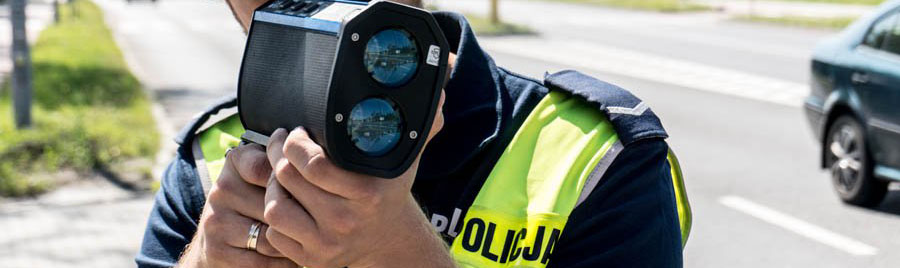 policjant drogówki z miernikiem prędkości w ręku