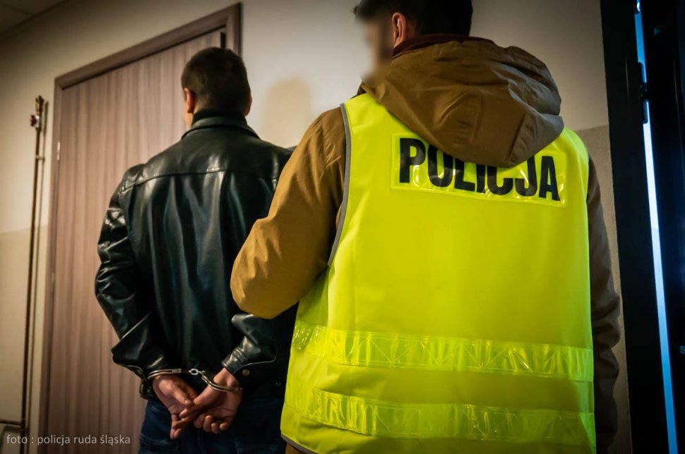 policjant z zatrzymanym w korytarzu komendy