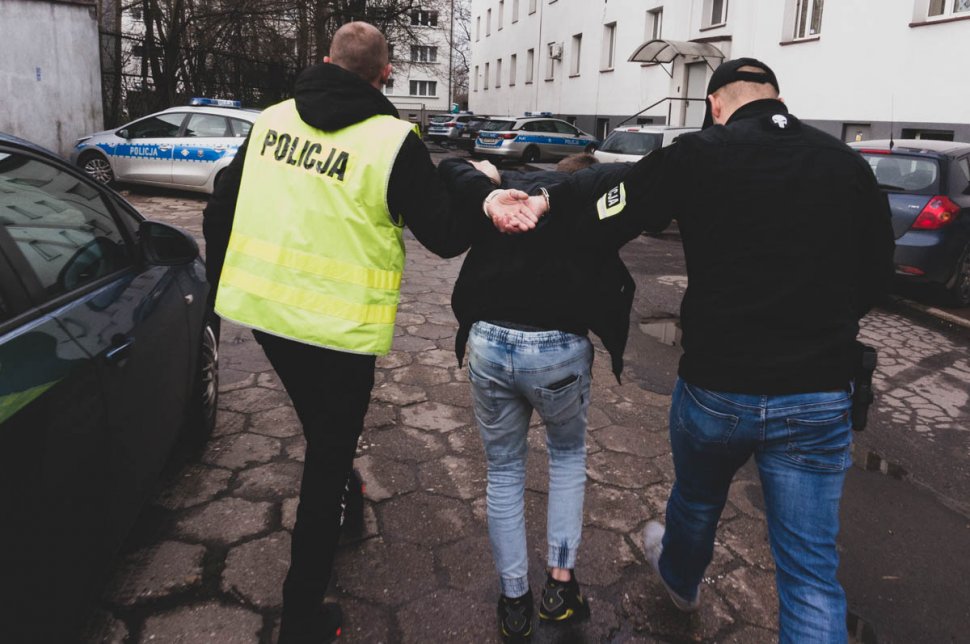 policjanci prowadzący zatrzymanego