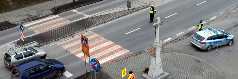zdjęcie przejścia dla pieszych i policjanta zatrzymującego samochód wykonane z powietrza